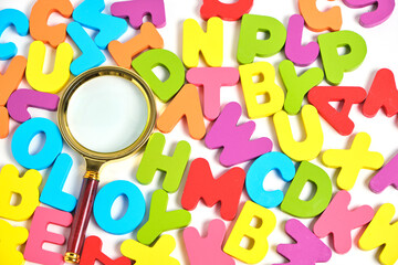 Magnifying glass and bright multicolored letters English alphabet.