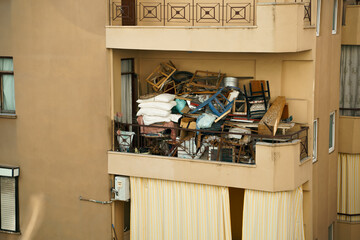 Ugly, terrible balcony disorder. Multi-storey building full of garbage, old furniture, unnecessary...