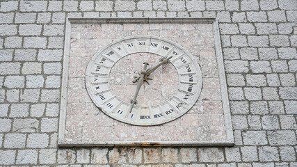 Fototapeta na wymiar Ancient stone clock on the wall. Old 24-hour clock.