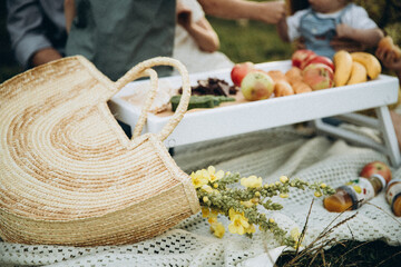 family picnic outdoors, wicker bag in foreground