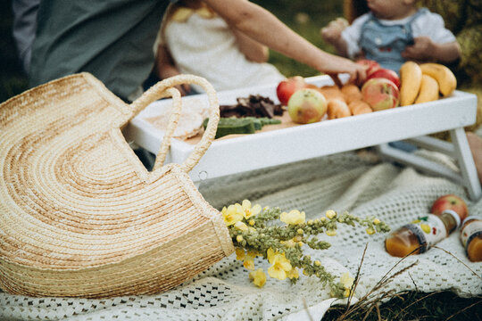 Family Picnic Outdoors, Wicker Bag In Foreground