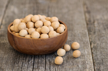 Brown Soy-covered Chickpeas with sauce in wooden bowl, traditional turkish coated nut 