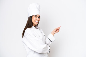 Young Brazilian chef woman isolated on white background pointing finger to the side