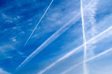 blue sky with airplane tracks and clouds 