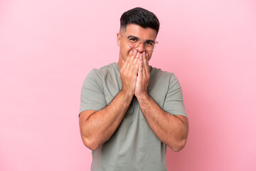 Young caucasian handsome man isolated on pink background happy and smiling covering mouth with hands