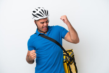 Young caucasian man with thermal backpack isolated on white background celebrating a victory