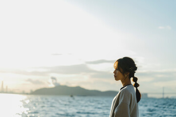 海で夕日を見ている女性