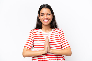 Young Colombian woman isolated on white background keeps palm together. Person asks for something