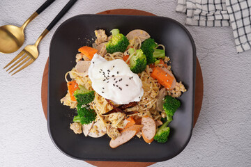 Stir-fried noodles with pork and egg, fresh vegetables, top view