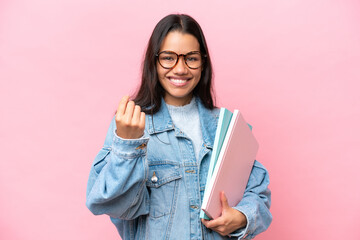 Young student Colombian woman isolated on pink background making money gesture