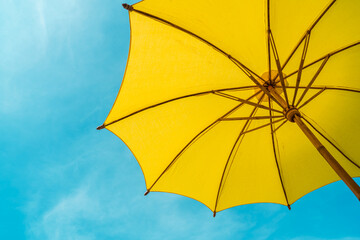 Obraz na płótnie Canvas yellow umbrella against blue sky