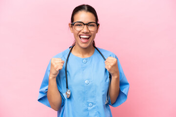 Young nurse Colombian woman isolated on pink background celebrating a victory in winner position