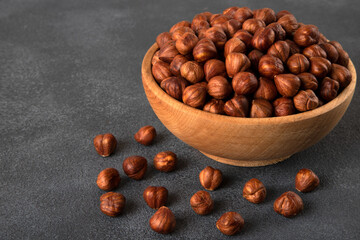 Top view of a bowl full of hazelnuts on dark background 