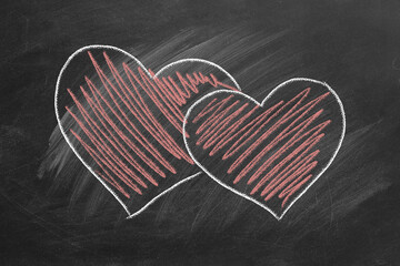 Two hearts are hand drawn with chalk on a blackboard. Valentines day. Love concept. I Love You