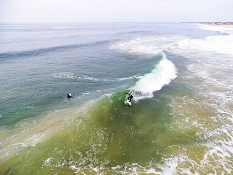 Two surfers near coast, Westerly, Rhode Island, USA