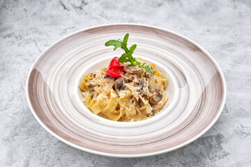 Pasta with mushrooms, cheese and tomatoes on a plate