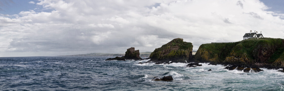 A house sits on the cliff in a panorama image of the United Kingdom coastline near St. Abbs.