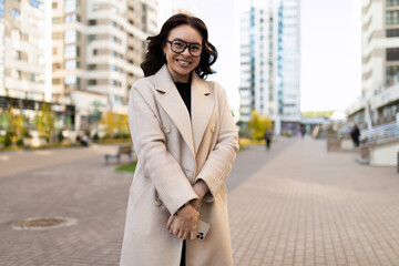 Obraz premium modest business woman with a smile looks at the camera on the background of the city