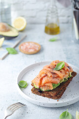 A rye bread sandwich with avocado and salmon	