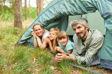 Happy family in tent camping in forest