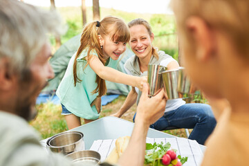 Family toasting mugs while enjoying breakfast at forest