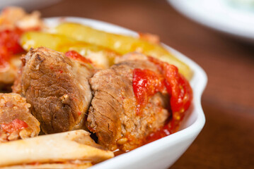 Khashlama is popular Armenian dish, which is prepared from beef with vegetables. Khashlama in the plate.  caucasian food. stewed lamb on the bone with vegetables on wooden desk