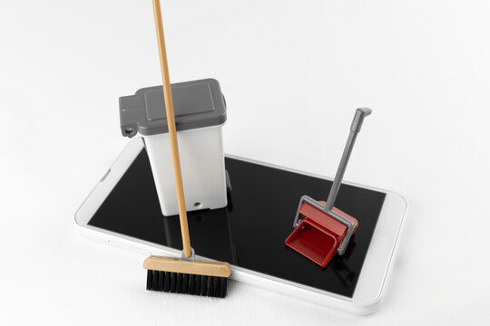 スマートフォンと玩具の掃除道具。コンピューターのクリーンアップイメージ