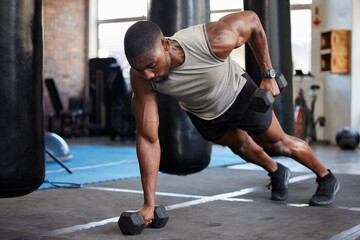 Black man, fitness and muscle training with dumbbells in gym, exercise with balance and strong...