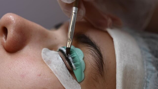 Close-up portrait of a woman on eyelash lamination procedure. 