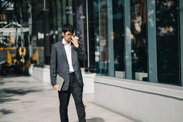 Asian Businessman walking outside office building..