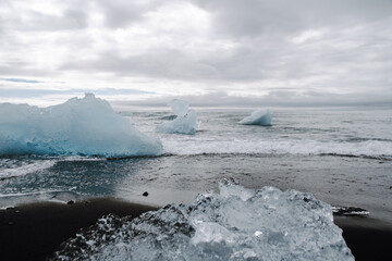 Chunks of ice washed up by the sea lie on the black beach of Breidamerkursandur ( Diamond Beach). They come from the broken icebergs from the glacier lagoon J&ouml;kuls&aacute;rl&oacute;n, which migrate into the sea.