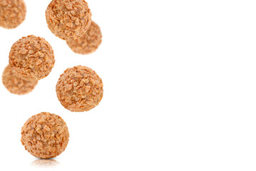 Levitation of round candies decorated with crushed nuts isolated on a transparent background.