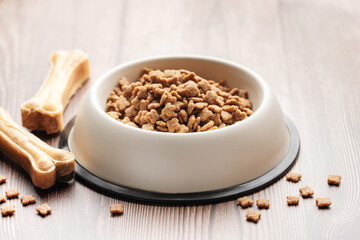 A bowl of dog food on a wooden floor.