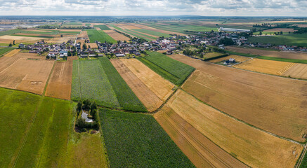 Fototapeta pola i łąki z miedzami i wioską z lotu ptaka obraz