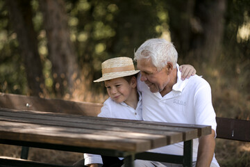 Fototapeta premium Happy senior man Grandfather with cute little boy grandson playing in forest