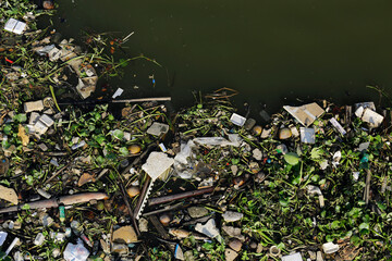 Aerial top down view of trash polluting the Saigon river, downtown Ho Chi Minh City, Vietnam.