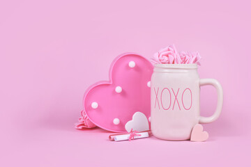 Cute Valentine's Day decoration with hearts, roses and XOXO mug on pink background