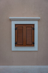Fototapeta premium Kleines Fenster am Haus mit Fensterläden. 