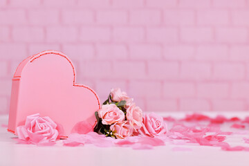 Valentine's Day composition with heart shaped box and rose flowers on pink background with copy space