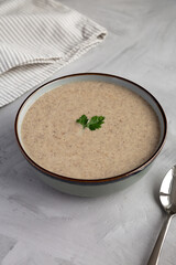 Homemade Cream of Mushroom Soup in a Bowl on a gray background, side view.