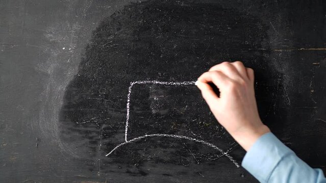 draw a house with chalk on a black board. home building concept. housing construction