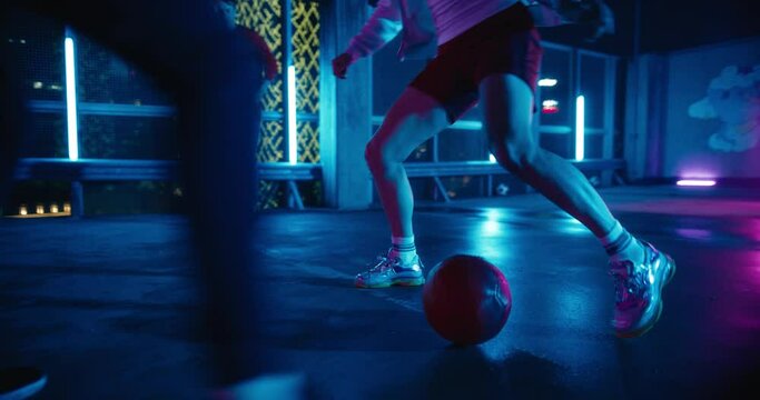Close Up Follow Shot of a Football Player Dribbling a Red Football Ball, Showing Off Tricks and Dodging Opponents. Friends Playing Street Soccer on a Rooftop Parking Lot with Neon Lights at Night