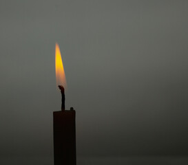 candle burning with backlight in the background