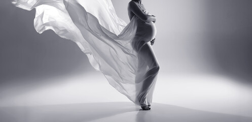 Fototapeta na wymiar A pregnant woman in a white dress.