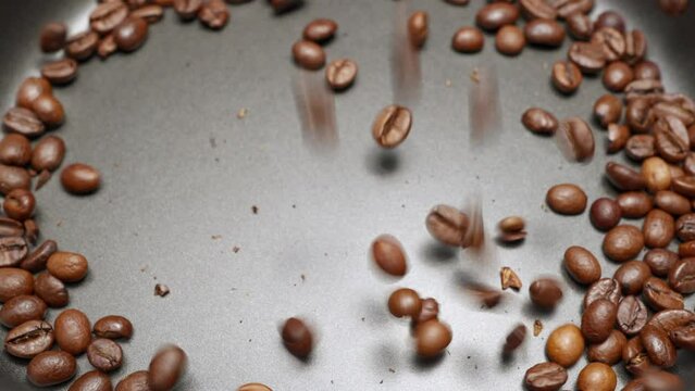 Kaffeebohnen fallen in Zeitlupe in einen Behälter 1