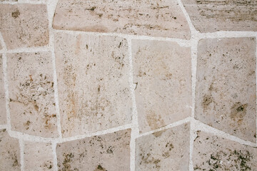 Paving stones, the road is paved with beige tiles. Stone texture, grunge background.
