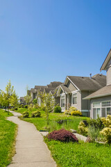 Concrete pathway along the row of residential houses on a sunny day