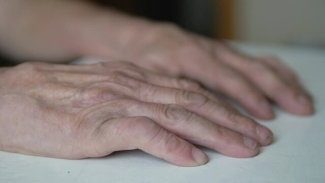  hand of an elderly person on the table. . the concept of elderly people, loneliness in old age, waiting for a pensioner, old parents, father's hands