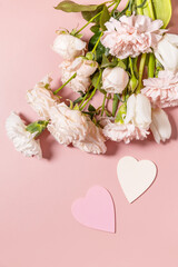 Valentine's Day greeting card with beautiful flowers on pink background. Valentine's day, Womans day, wedding, birthday or mothers day. View from above. Copy space.