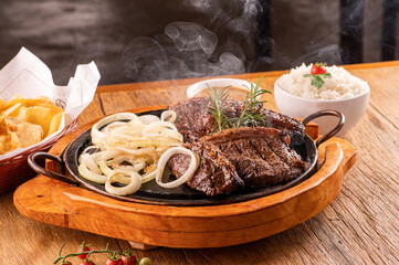 picanha fatiada no ponto saindo fumaça deliciosa cebola espado no garfo com arroz guarniçoes 